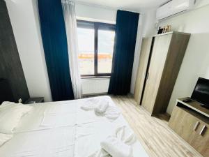 una camera da letto con un grande letto bianco e una finestra di Mamaia a Mamaia