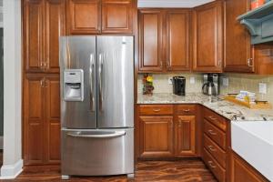 Una cocina con gabinetes de madera y un refrigerador de acero inoxidable. en Dolphin Point 305B- by Holiday Isle Properties, en Destin 130 fotos más