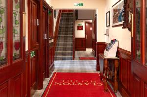 a hallway with a red rug on the floor at Claxton Hotel in Redcar