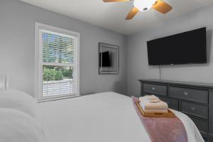 a bedroom with a bed and a flat screen tv at Charming Duplex on Main in St. Charles