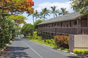 an empty street next to a building with palm trees at Kihei Akahi Resort - Unit C313 in Wailea