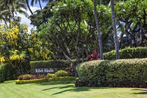 a sign in a park with trees and bushes at Kihei Akahi Resort - Unit D114 in Wailea