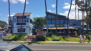 a blue building with people walking in front of it at Kihei Akahi Resort - Unit D114 in Wailea