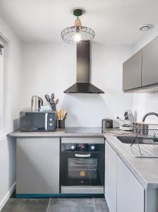 a kitchen with a sink and a stove in it at L'atelier d'Anatole in Oyonnax