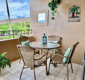 a table and chairs on a patio with a view at Island Sands 401 in Wailuku