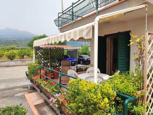 a porch of a house with a table and flowers at Sea Garden, fronte mare con piscina in Mascali