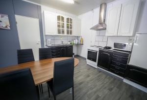 a kitchen with a wooden table and black appliances at Hostelli Karvia in Karvia