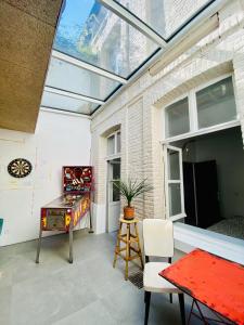 a room with a glass ceiling with a ping pong table at Oasis Urbaine - Spacieux et calme avec patio in Lille
