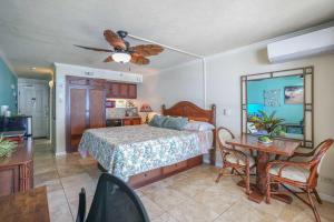 a bedroom with a bed and a table and a dining room at Islander on the Beach 328 in Kapaa +48 photos