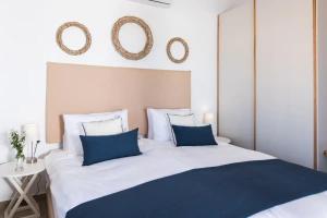 a bedroom with a bed with blue pillows and mirrors at Villa Alia in Sfakiá