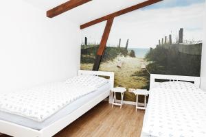 two beds in a room with a view of the ocean at Landleev - Bauernhof "Hofbude Fehmarn" in Fehmarn