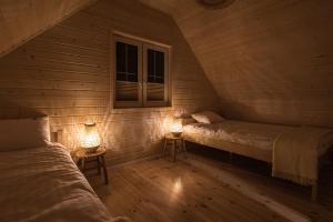a room with two beds and two lamps in it at Off White Domki Darłówko in Darlowko +37 photos