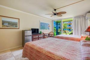 a hotel room with two beds and a television at Islander on the Beach 115 in Kapaa +42 photos