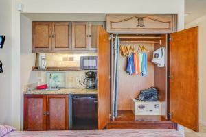 a small kitchen with wooden cabinets and a sink at Islander on the Beach 115 in Kapaa