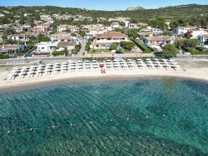 an aerial view of a beach with chaises and chairs at Blu Hotel Laconia Village in Cannigione