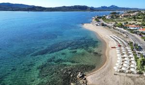 an aerial view of a beach with umbrellas and the water at Blu Hotel Laconia Village in Cannigione