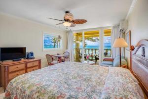 een slaapkamer met een groot bed en een televisie bij Islander on the Beach 323 in Kapaa +49 foto's