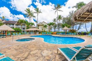 een zwembad met stoelen en parasols in een resort bij Islander on the Beach 323 in Kapaa