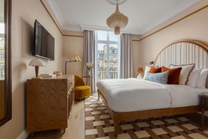 a hotel room with a bed and a window at Miiro Le Grand Hôtel Cayré in Paris