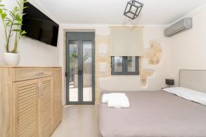 een slaapkamer met een bed en een tv aan de muur bij Myra city House in Chania