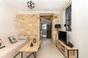 een woonkamer met een bank en een tv bij Myra city House in Chania