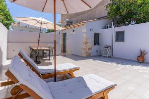 een patio met stoelen, een parasol en een tafel bij Myra city House in Chania