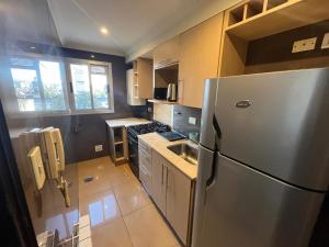 a kitchen with a stainless steel refrigerator and a sink at Dpto vista al cerro in Salta