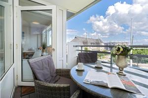 a balcony with a table and chairs with a view at Am Stadtpark in Westerland (Sylt) +16 photos