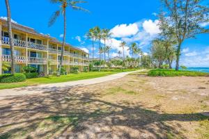 an exterior view of a resort with palm trees at Islander on the Beach 152 in Kapaa