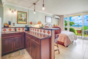 a kitchen with a sink and a bed in a room at Islander on the Beach 152 in Kapaa +49 photos