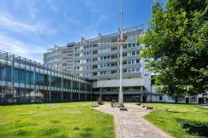 a large white building with a grass field in front of it at Am Stadtpark in Westerland (Sylt)
