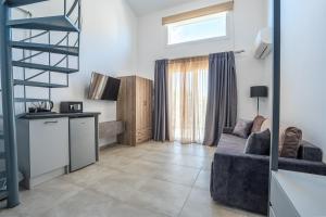 ein Wohnzimmer mit Sofa und eine Küche in der Unterkunft Charisma Resort in Ímeros