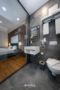 a bathroom with a sink and a toilet and a bed at B-Chill Cologne in Cologne