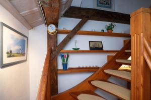 a spiral staircase in a tiny house with a clock at Sylter Seestern App Ual Skiin in Archsum +13 photos