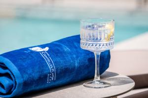 a glass of water sitting next to a blue towel at Canyelles Platja in Roses