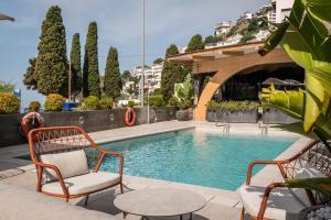 a swimming pool with two chairs and a table at Canyelles Platja in Roses