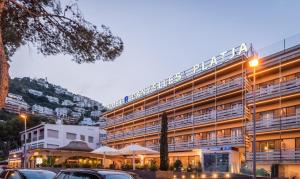 a large building with cars parked in front of it at Canyelles Platja in Roses