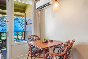 a dining room with a table and chairs and a window at Islander on the Beach 363 in Kapaa