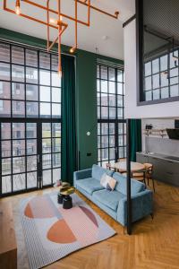 a living room with a blue couch and a table at Hotel de Timmerfabriek I Kloeg Collection in Vlissingen