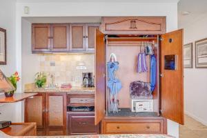 a kitchen with a cupboard with a microwave and a counter at Islander on the Beach 131 in Kapaa