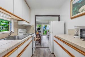 una cocina con fregadero y refrigerador en Kapaa Sands 19, en Kapaa