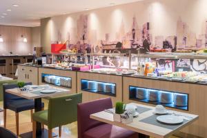 a restaurant with two tables and a counter with food at Hotel Castellon Center Affiliated by Meliá in Castellón de la Plana