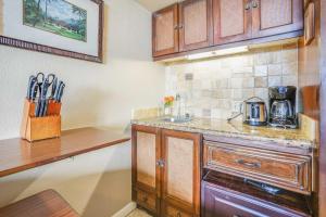 a kitchen with wooden cabinets and a counter top at Islander on the Beach 151 in Kapaa