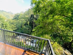 a balcony with a view of a river and trees at River Splendour Home Stay in Ella