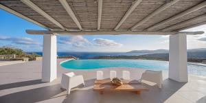 a patio with a table and chairs and a pool at Villa Zen Mykonos in Mýkonos City +5 photos