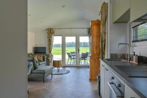 a kitchen and living room with a view of a patio at Luxe Lodge voor 4 personen - Rolstoel-toegankelijk in Hoogersmilde