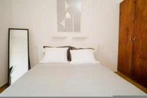Un dormitorio con una gran cama blanca con dos almohadas. en Elle74 Platanidia, en Platanidia