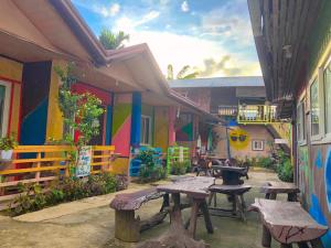 a patio with benches and tables in front of a building at Mama Hostel & Guest House in El Nido