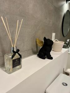 a bathroom shelf with a black teddy bear and a mirror at Parenthèse Bretonne in Ploërmel +2 photos