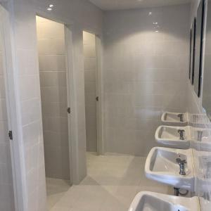 a bathroom with three sinks and a shower at Labkoff cafe and Hostel in Kanchanaburi +84 photos